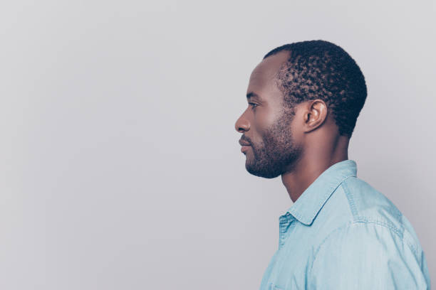 istock Half-faced side profile view portrait of thoughtful pensive serious confident handsome guy dressed in light blue shirt, isolated on grey background 925466532