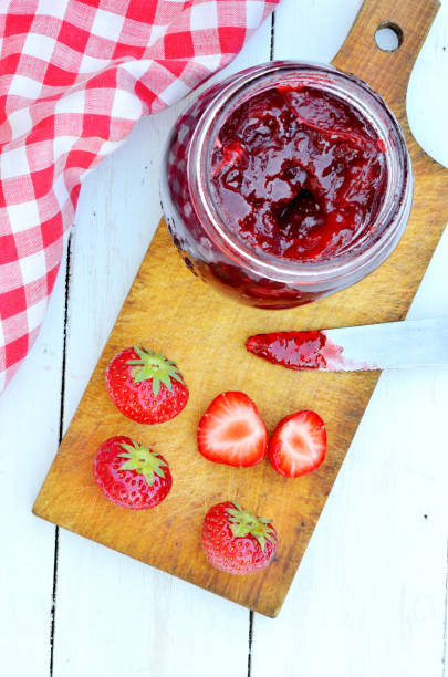 istock Jar of strawberry jam and fresh strawberries on white table 925470504