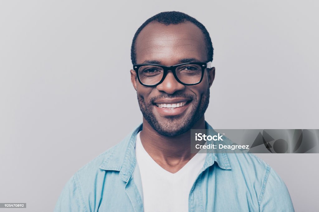 Close up portrait of confident handsome clever cheerful joyful university professor wearing casual denim jeans shirt and black rim-glasses, isolated on gray background Men Stock Photo