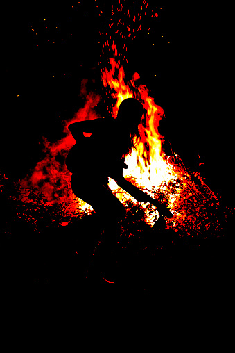 Guitarist Lindy Day performing at night by a bonfire. Sonoma County, California.
