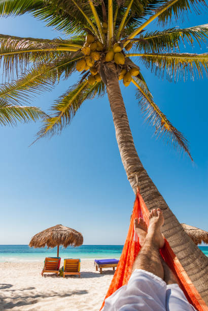 istock Young man relaxing on a tropical beach 925475582