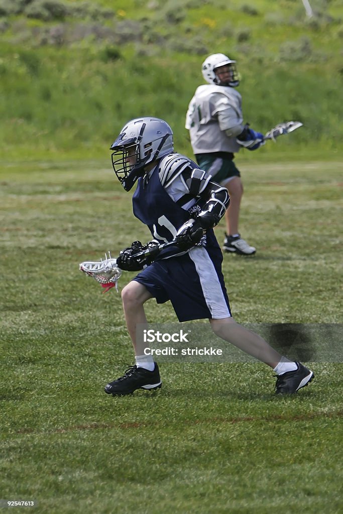 Joven masculino sobre ataque reproductor de Lacrosse - Foto de stock de Adversidad libre de derechos