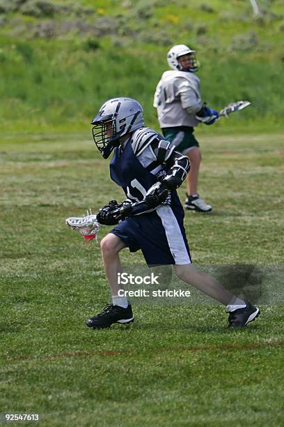 Joven Masculino Sobre Ataque Reproductor De Lacrosse Foto de stock y más banco de imágenes de Adversidad