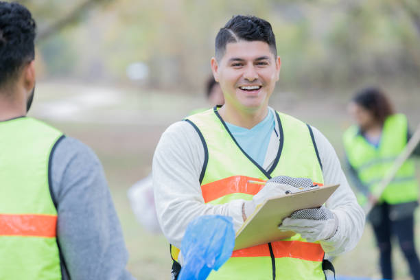 istock Male volunteer community cleanup coordinator instructs volunteers 925477096