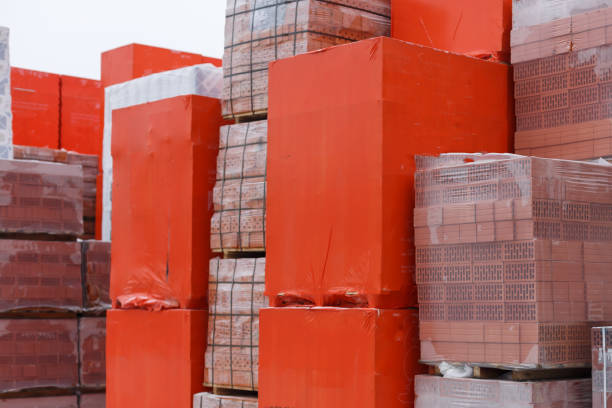 istock Brown decorative bricks stacked on a pallet on a blurred background of other building material 925489430