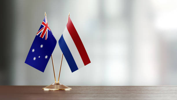 istock Australian And Dutch Flag Pair On A Desk Over Defocused Background 925493872