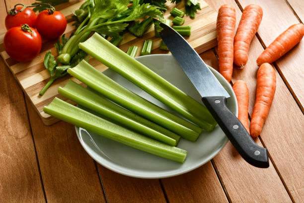 istock celery, carrots and tomato with knife beside 925494412
