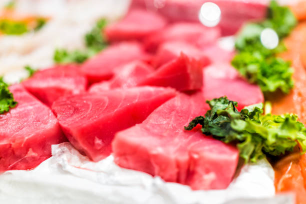 stand de marisco com cortes de bifes de atum-de-rosa vermelho selvagem de criação no gelo com folhas de couve - tuna prepared ahi sashimi sushi - fotografias e filmes do acervo