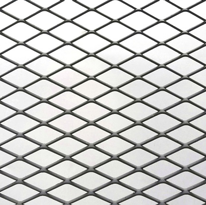 Close-up of defocused rusty wire mesh fence against white background.