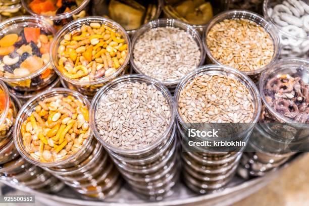 Photo libre de droit de Beaucoup Emballé Graines Noix Fruits Secs Dans Des Contenants De Plastique Sur Laffichage Dans Le Magasin Magasin Rayonnages Mélange De Graines De Tournesol Bretzels banque d'images et plus d'images libres de droit de Aliment