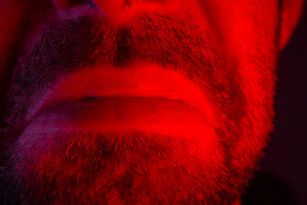 Macro closeup on man lips with sad facial expression. Portrait of melancholy face.