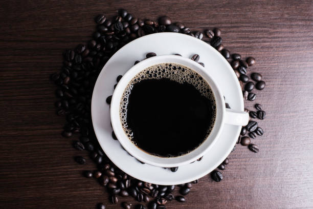 istock Black coffee in white cup and coffee bean on wood table background. 925507640