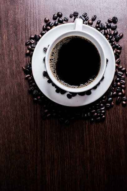 istock Black coffee in white cup and coffee bean on wood table background. 925507792