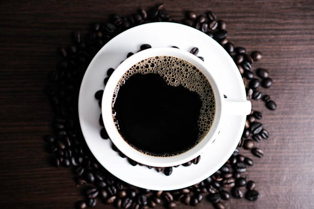 istock Black coffee in white cup and coffee bean on wood table background. 925510644