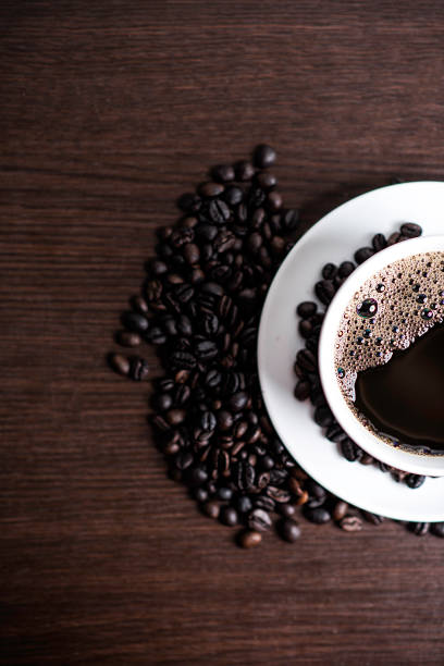 istock Black coffee in white cup and coffee bean on wood table background. 925510982