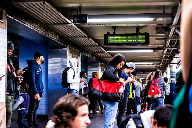 personnes en attente dans la plate-forme grand vide souterrain de transport en commun dans la station de métro de new york au centre-ville, en regardant les téléphones sur fulton street - subway station subway train new york city people photos et images de collection