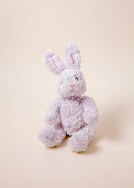 istock Toys: small pink or lilac rabbit, isolated on beige background 925516756