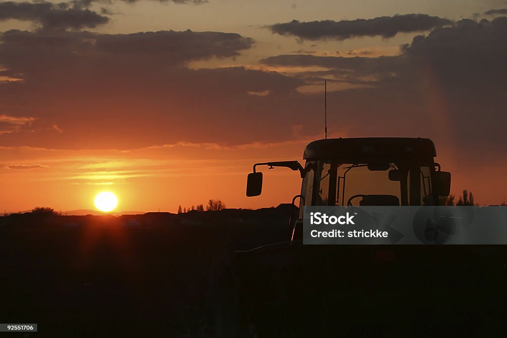 КЭБ сельскохозяйственных комбайн в Silhouetted на закате - Стоковые фото Вечерние сумерки роялти-фри