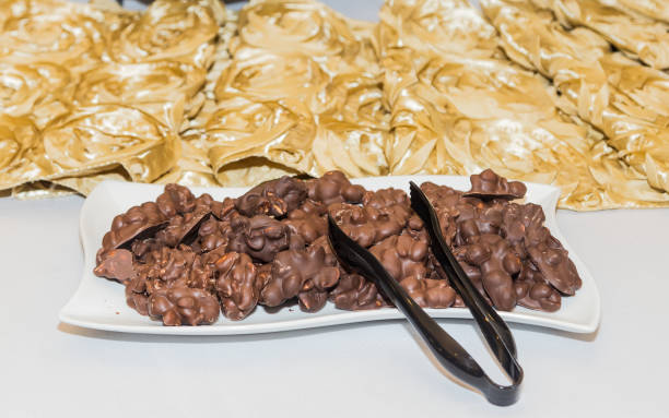 Chocolate Peanut Clusters Arrangement at White and Gold Themed Party stock photo