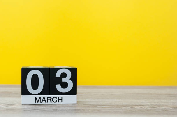 istock March 3rd. Day 3 of month, calendar on table with yellow background. Spring time, empty space for text 925550200