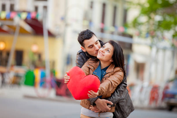 Young couple with heart shape toy kissing