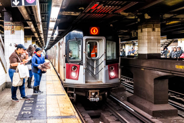 personas que esperan en tránsito subterráneo vacío gran plataforma en la estación de metro de nueva york, vías del ferrocarril, mujer comiendo, tren entrante - stair rail fotografías e imágenes de stock