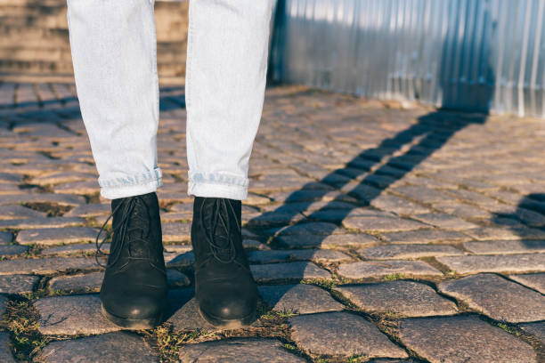 istock Women's legs in jeans and black shoes 925561156