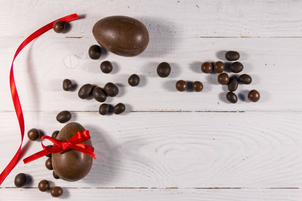 istock Easter composition with chocolate eggs on white wooden background 925563154