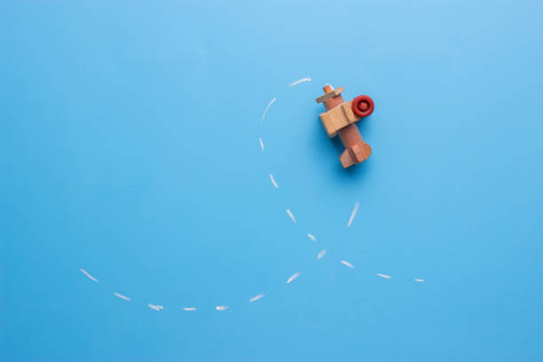 istock wooden plane performs a loop across the surface of a blackboard. 925565352
