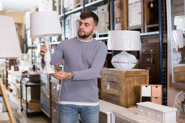 istock Man looking for table lamp in shop 925565952