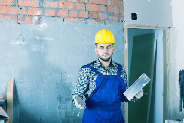 istock Craftsperson in the helmet ready is plastering the wall 925566094