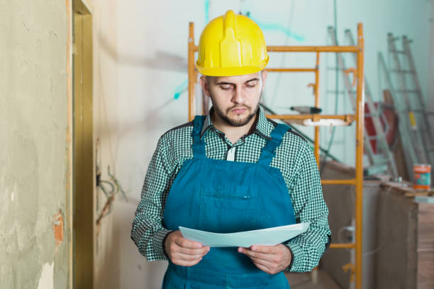 istock Plasterer is looking on the project of work for the object. 925566118