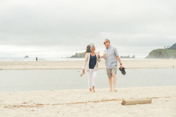 istock Senior couple enjoy ice cream cones together on the beach 925566708