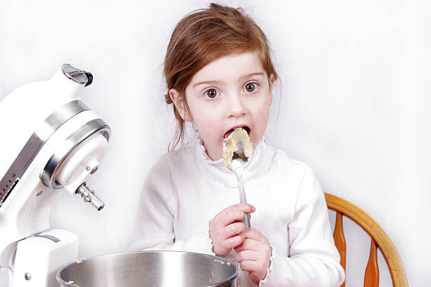 パン少女 - licking spoon child electric mixer ストックフォトと画像