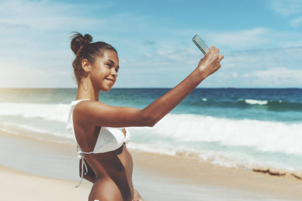 istock Ebony female taking selfie on the beach on cellphone 925574978