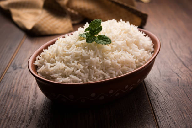 istock Cooked plain white basmati rice in terracotta bowl over plain or wooden background 925578182