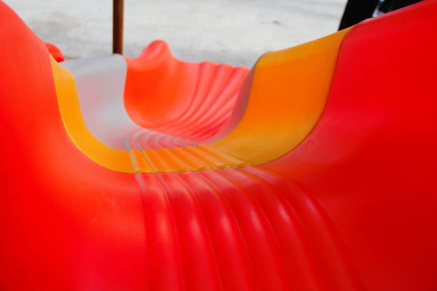 Close-up on a red slide in a children's park surrounded by a barrier