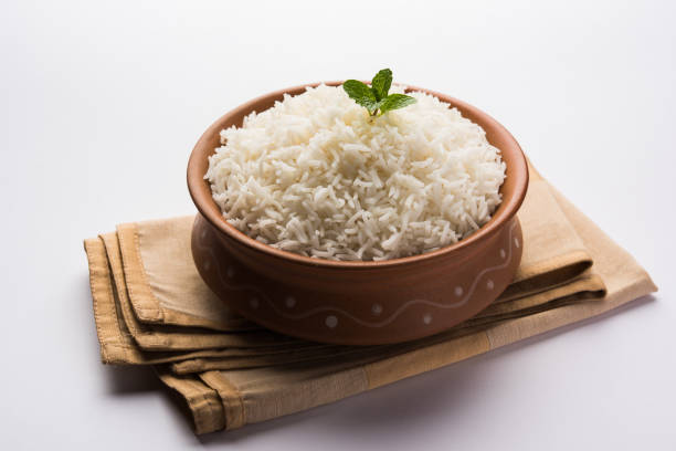 istock Cooked plain white basmati rice in terracotta bowl over plain or wooden background 925578570