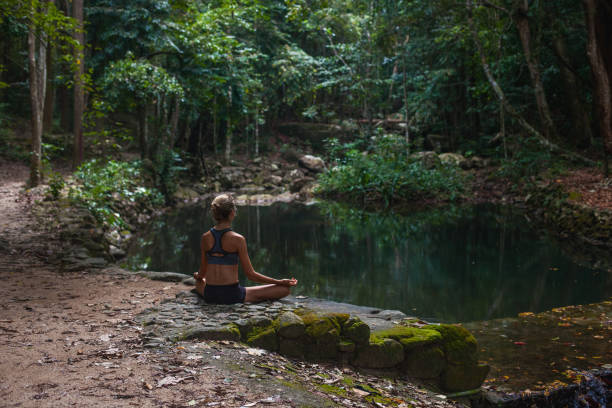 istock Woman mediting  in tropical forest 925581424