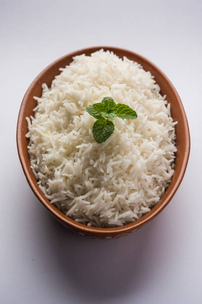 istock Cooked plain white basmati rice in terracotta bowl over plain or wooden background 925582346