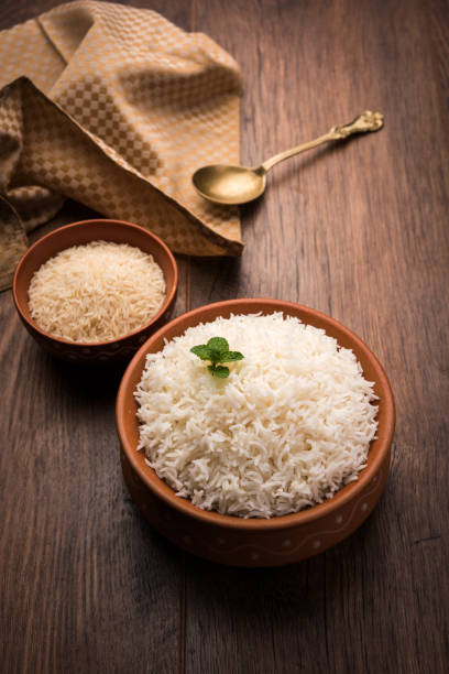 istock Cooked plain white basmati rice in terracotta bowl over plain or wooden background 925582594