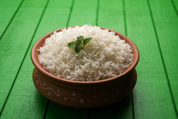 istock Cooked plain white basmati rice in terracotta bowl over plain or wooden background 925582674