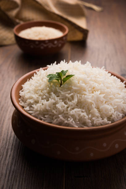 istock Cooked plain white basmati rice in terracotta bowl over plain or wooden background 925583180