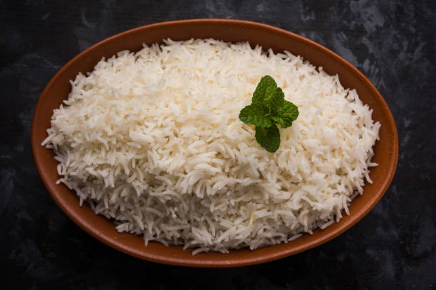istock Cooked plain white basmati rice in terracotta bowl over plain or wooden background 925585450
