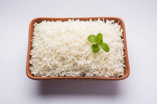 istock Cooked plain white basmati rice in terracotta bowl over plain or wooden background 925585590