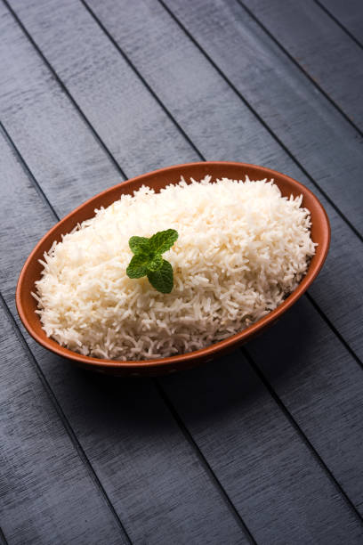istock Cooked plain white basmati rice in terracotta bowl over plain or wooden background 925586006