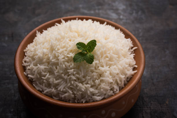 istock Cooked plain white basmati rice in terracotta bowl over plain or wooden background 925586322