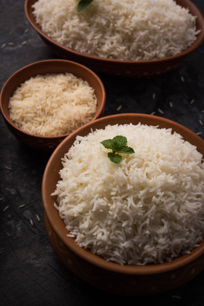 istock Cooked plain white basmati rice in terracotta bowl over plain or wooden background 925586938