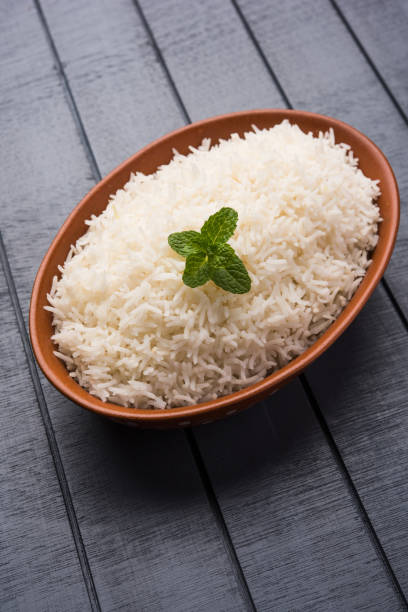 istock Cooked plain white basmati rice in terracotta bowl over plain or wooden background 925589562