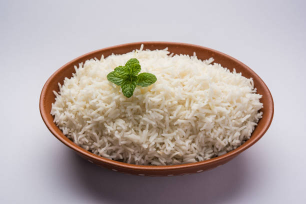 istock Cooked plain white basmati rice in terracotta bowl over plain or wooden background 925590280